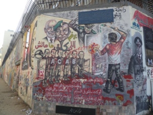 And the walls were updated with the pictures of the latest martyrs and targets of political rejection. Here, the Muslim Brotherhood's General Guide hovers behind a split image of Mubarak and former army General Tantawi.