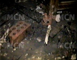 Photo of a brick thrown through the window, reportedly taken from inside St. George Church, by a woman who snuck a camera past security.