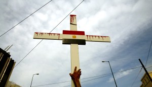 Egyptian Coptic Christian holds cross during a demonstration outside Egyptian embassy in Athens