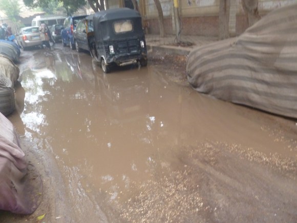 This is the puddle right in front of the entrance to Emma's and Hannah's school. The black vehicle is a tuk-tuk, stuck in the mud-mud.