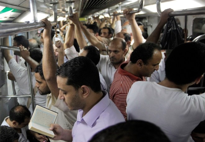 An Egyptian man reads the Quran while riding the metro (AP Photo/Amr Nabil)