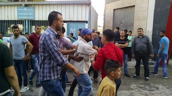 A man whose young brother has just been slain by an Israeli soldier is restrained by friends. Photo: ‘William’, Peace Parcels